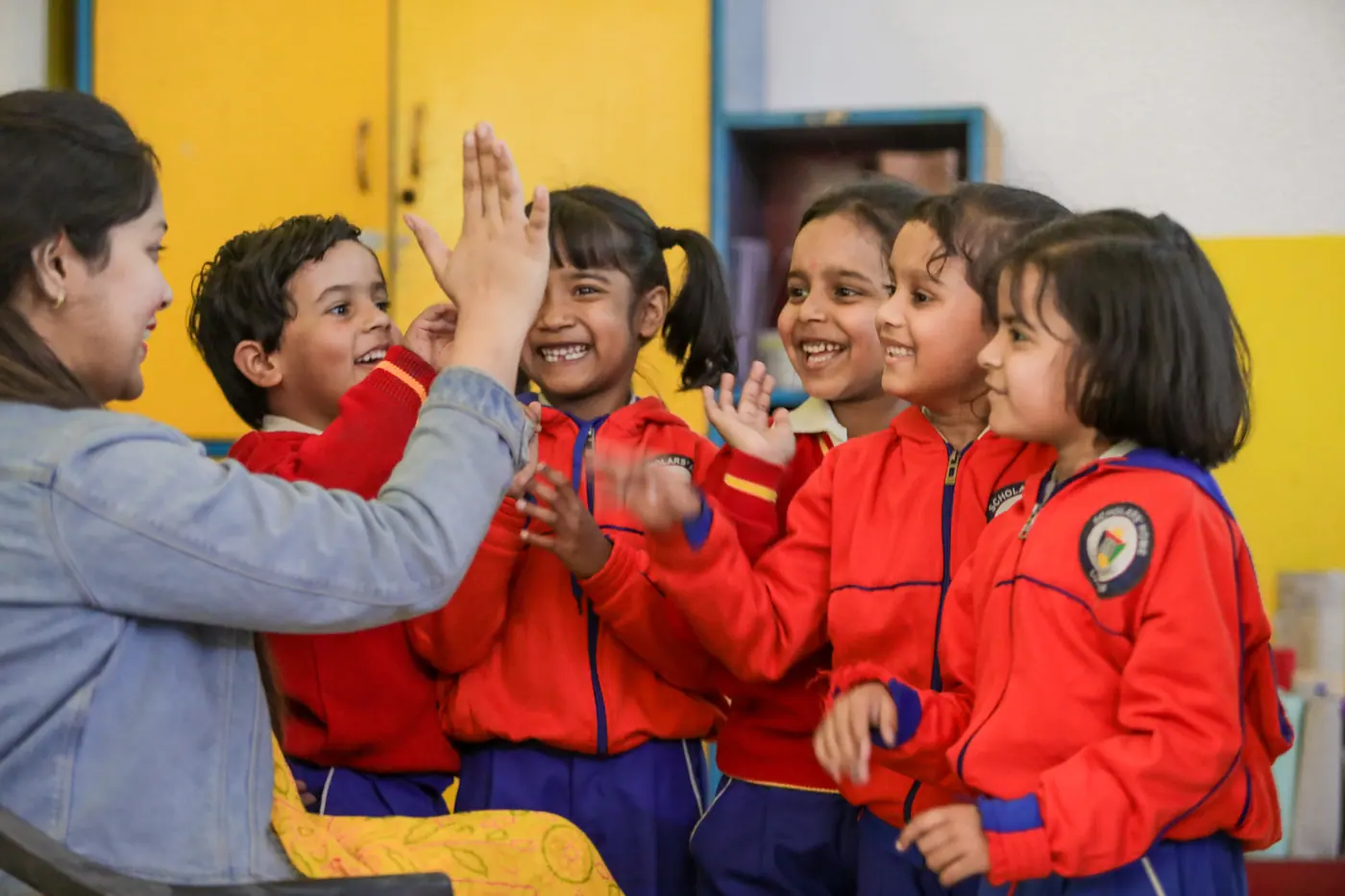 Primary students high-fiving in class